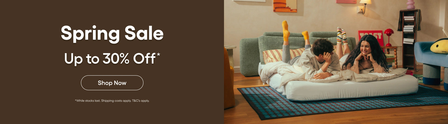 Promotional banner for a spring sale with a couple on a bean bag chair in a living room.