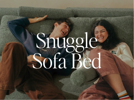 Two people lying on a sofa with text 'Snuggle Sofa Bed' displayed.